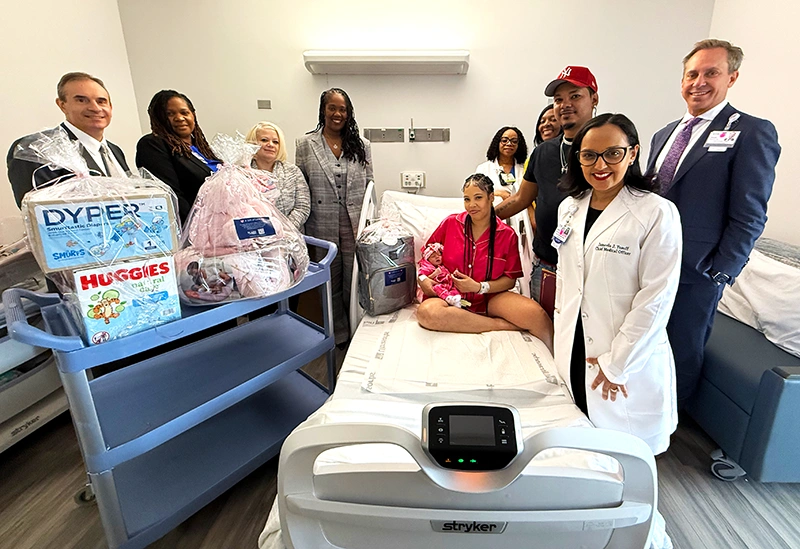 Shanika Gonzalez and Christopher Norberto Sepulveda welcomed their daughter Jahzelle on Mother’s Day. They are pictured with Donald T. Morrish, MD, MMM (right), Chief Executive Officer of EHS, and (from left): Steven Guido, Executive Vice President & Chief Financial Officer, Keisha-Ann Wisdom, DHA, MBA, BSN, RN, NEA-BC, Senior Vice President of Patient Services & Chief Nursing Officer, Marissa DeLaCruz, MSN, RN, RNC-OB, Director of Nursing, Maternal Child Health, Jacqueline Marecheau, MD, FACOG, Chairperson, Department of Obstetrics & Gynecology, Roseline Utti, DNP, RN, RNC-OB, C-EFM, Nurse Manager, Maternal Child Health, Sharika Gordon, Senior Vice President & Chief People Officer and Jameela Yusuff, MD, MPH, Senior Vice President & Chief Medical Officer.